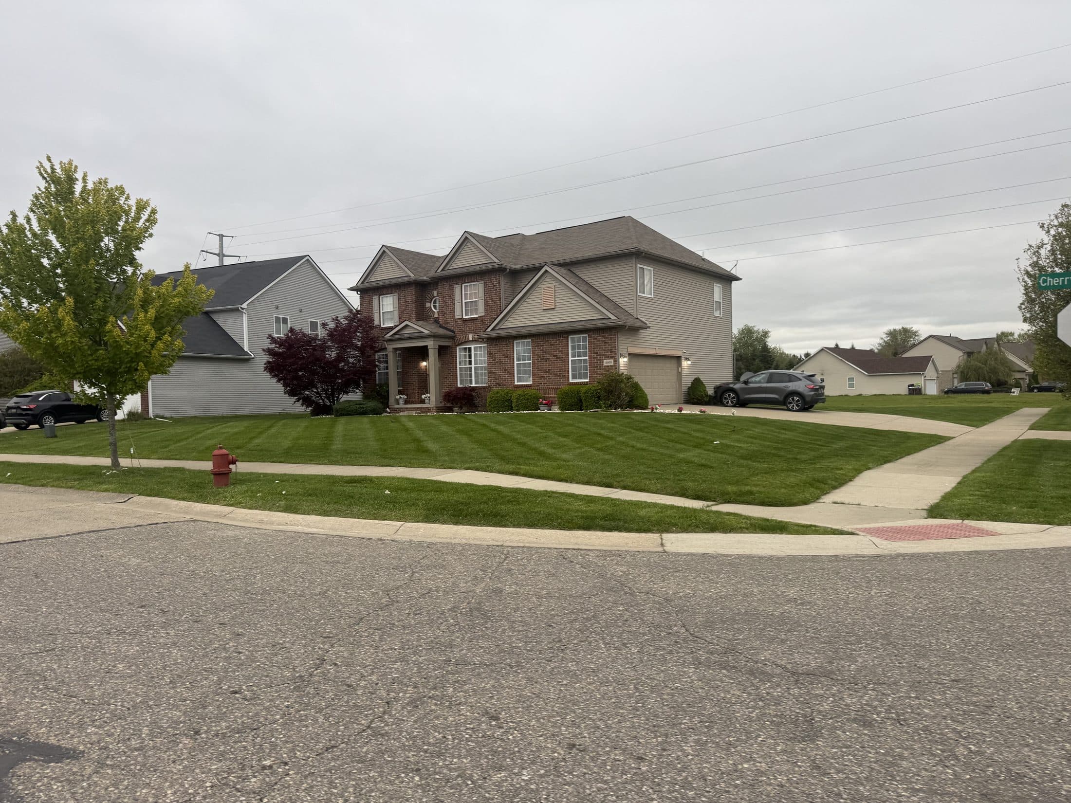 A front lawn cut in clean stripes with crisp edges along the driveway and walkway