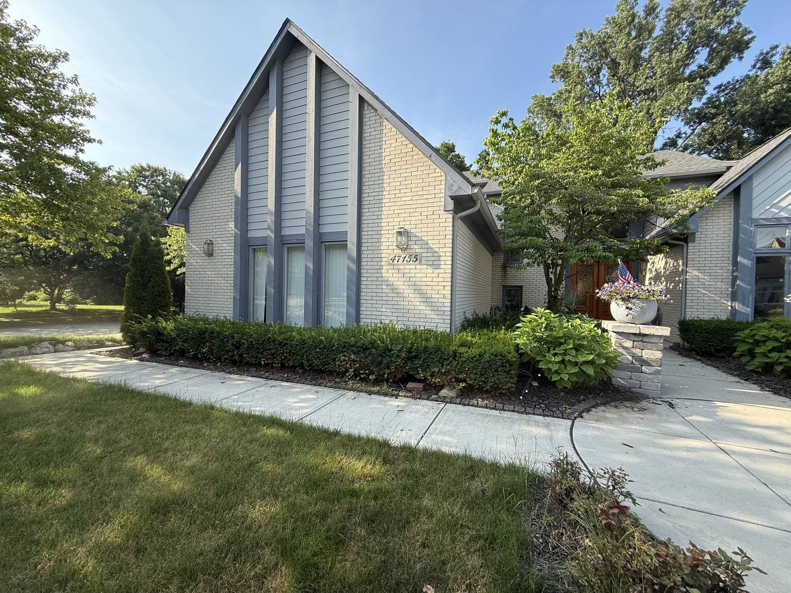 Neatly trimmed low shrubs lining the front walkway of a home