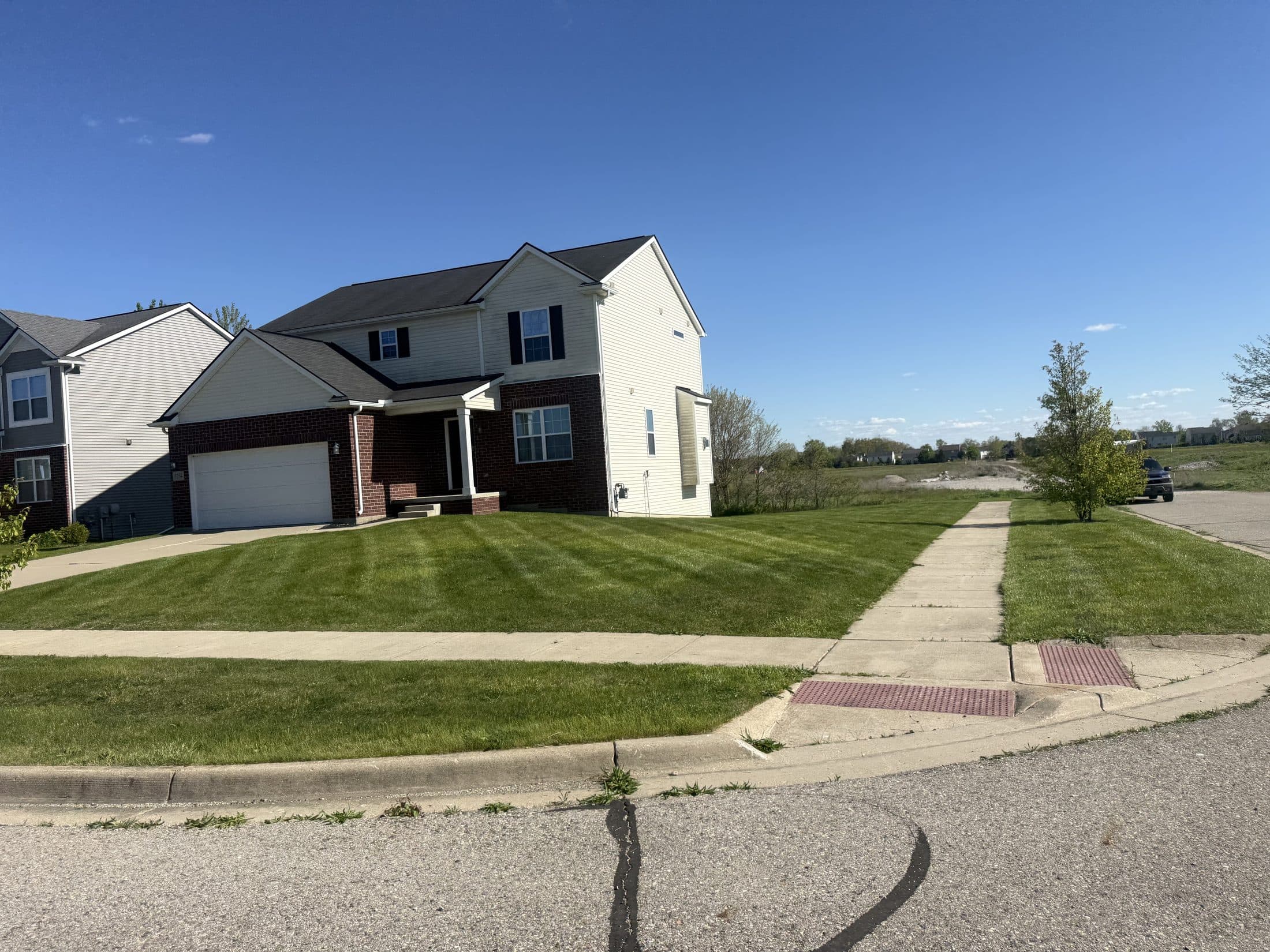 A two-story home with a freshly striped front lawn
