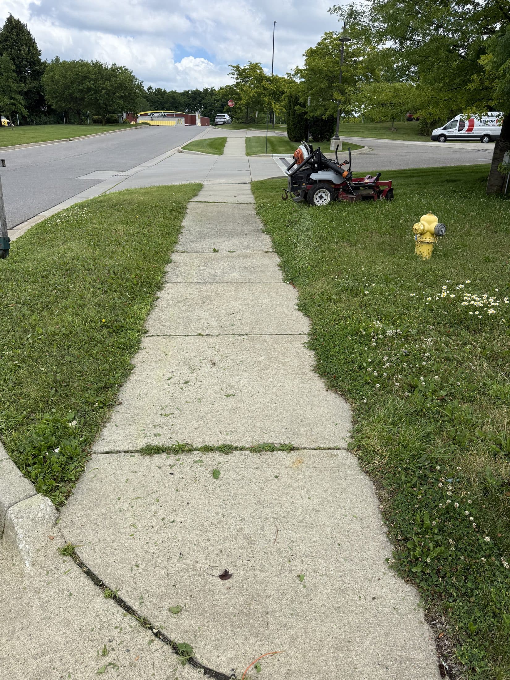 A riding mower maintaining the lawn at a commercial property
